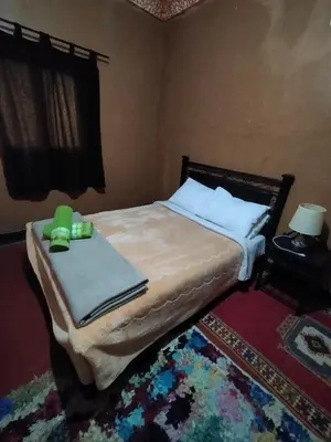 a bedroom with a bed with two green candles on it at auberge restaurant tizgui in Tinerhir