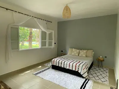 a bedroom with a bed and a window at Maison d Hôte Ighrem in Goulmima