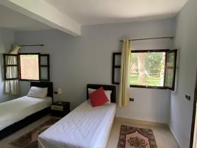 a bedroom with two beds and a window at Maison d Hôte Ighrem in Goulmima