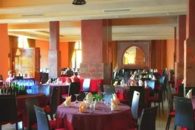 a dining room with tables and chairs with purple table cloth at Chems Du Lac Bin El Ouidane in Bine el Ouidane