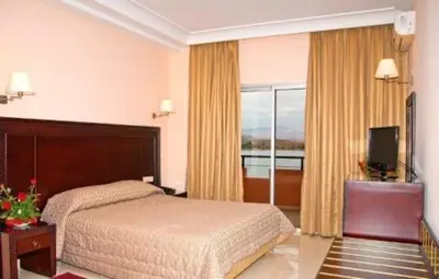a hotel room with a bed and a television at Chems Du Lac Bin El Ouidane in Bine el Ouidane