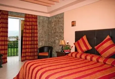 a bedroom with a large bed and a balcony at Chems Du Lac Bin El Ouidane in Bine el Ouidane