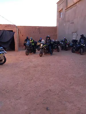 a group of people on motorcycles parked next to a building at Kasbah tifaoute ait Ben haddou in Aït Ben Haddou