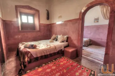 a small bedroom with a bed and a mirror at Kasbah tifaoute ait Ben haddou in Aït Ben Haddou