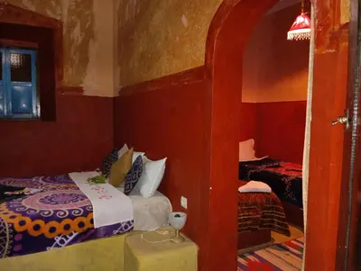 a small bedroom with a bed and a mirror at Kasbah tifaoute ait Ben haddou in Aït Ben Haddou