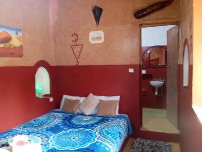 a bedroom with a bed and a sink at Kasbah tifaoute ait Ben haddou in Aït Ben Haddou