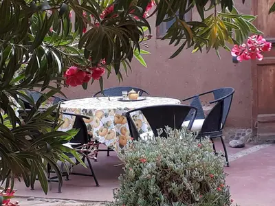 a table and chairs in a garden with flowers at Dar Paru in Mhamid