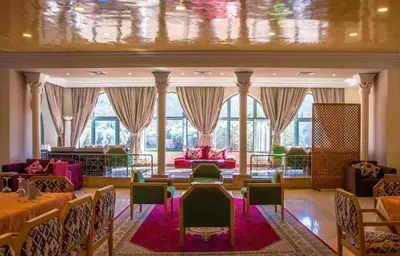 a large room with tables and chairs and windows at Chems Le Tazarkount in Afourer