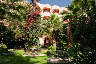 a garden with tables and chairs and flowers at Chems Le Tazarkount in Afourer
