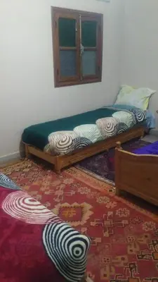 a bedroom with two beds and a window at Le Lion D'or Atlas in Telouet