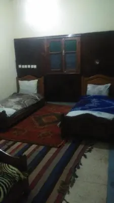 a bedroom with two beds and a rug at Le Lion D'or Atlas in Telouet