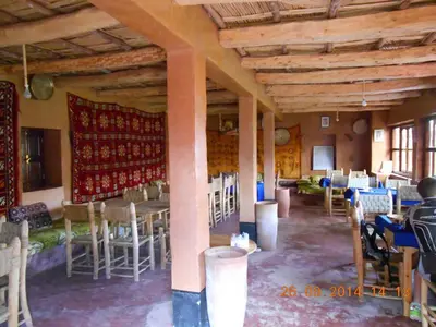 a room with chairs and tables in a room with wooden ceilings at Le Lion D'or Atlas in Telouet