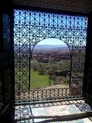 an open gate with a view of a green field at Le Lion D'or Atlas in Telouet