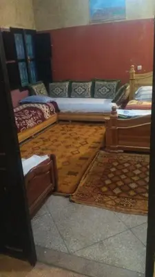 a room with two beds and a rug at Le Lion D'or Atlas in Telouet