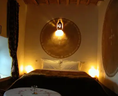 a bedroom with a bed with a large mirror on the wall at Kasbah Iswan in Kalaat MGouna