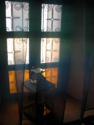 a room with two windows and a table in front at Kasbah Iswan in Kalaat MGouna