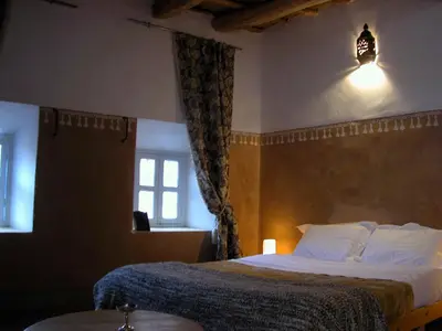 a hotel room with a bed and a window at Kasbah Iswan in Kalaat MGouna