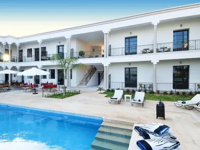 a hotel with a swimming pool in front of a building at Villa Agapanthe in Fès