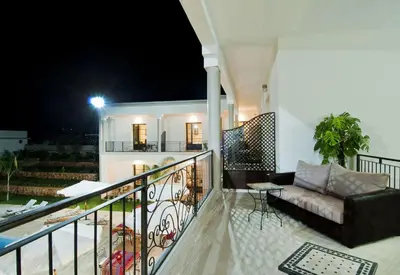 a balcony with a couch and a table at night at Villa Agapanthe in Fès
