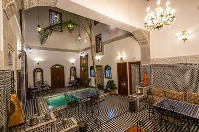 an indoor swimming pool in a building with a chandelier at Le Cèdre D'argent in Fès