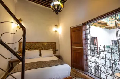 a bedroom with a bed next to a window at Le Cèdre D'argent in Fès