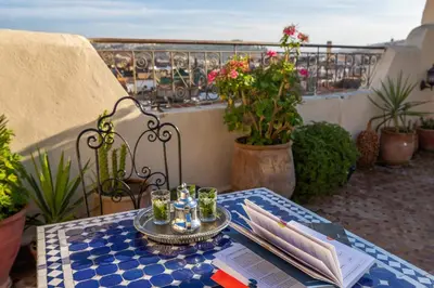 a table on a balcony with a view of the ocean at Le Cèdre D'argent in Fès