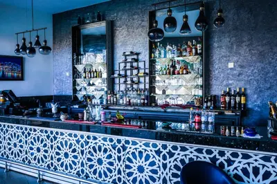 a bar with a blue and white patterned counter at Hotel La Perle du Sud in Ouarzazate