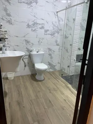 a bathroom with a toilet and a sink and a shower at Hotel La Perle du Sud in Ouarzazate