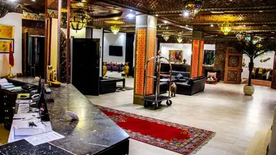 a large room with a counter and a red rug at Hotel La Perle du Sud in Ouarzazate