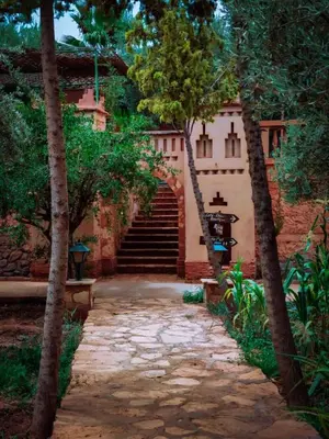 a stone walkway leading to a building with stairs at Hôtel LAKASBAH Ait Ben Haddou in Aït Ben Haddou