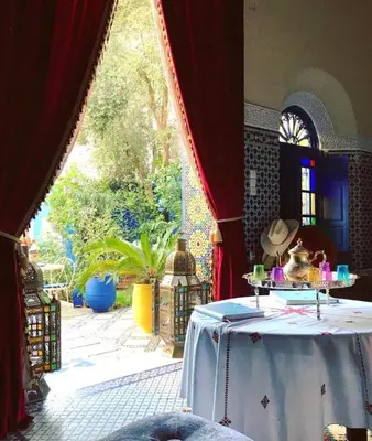 a table in a room with a large window at Riad Jean Claude in Fès