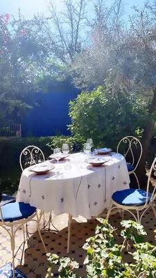 a white table with chairs and wine glasses on it at Riad Jean Claude in Fès