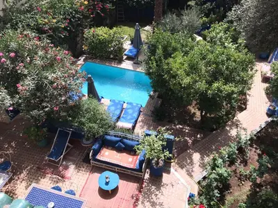 an overhead view of a swimming pool with chairs and trees at Riad Jean Claude in Fès