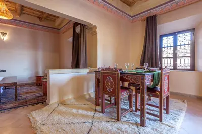 a dining room with a table and chairs at Kasbah Tizzarouine in Boumalne