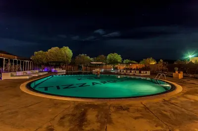 a swimming pool at night with a dark sky at Kasbah Tizzarouine in Boumalne