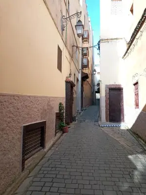 an alley way in an old town with buildings at Riad Les Remparts De Fès in Fès