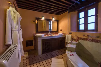 a bathroom with a tub and a sink and a mirror at Riad Les Remparts De Fès in Fès