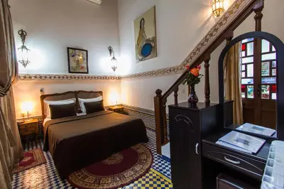 a bedroom with a bed and a stairway at Riad Les Remparts De Fès in Fès