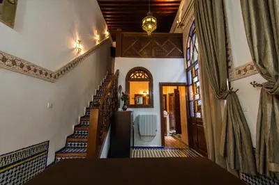 a hallway of a home with a staircase and a door at Riad Les Remparts De Fès in Fès