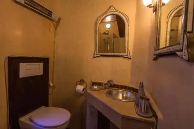 a bathroom with a sink and a toilet and a mirror at Riad Les Remparts De Fès in Fès