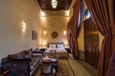 a hotel room with a bed and a couch at Riad Les Remparts De Fès in Fès
