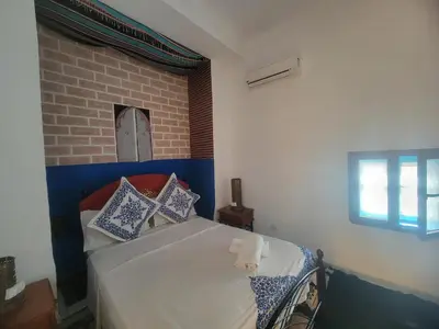 a bedroom with a bed with blue and white pillows at Riad Dar Lemdrssa in Fès