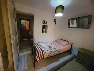 a small bedroom with a bed and a walk in shower at Riad Dar Lemdrssa in Fès