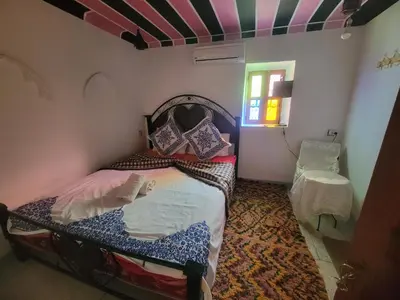 a small bedroom with a bed and a window at Riad Dar Lemdrssa in Fès