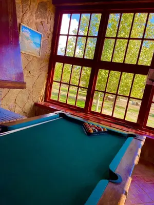 a pool table in a room with windows at Ferme D’hôte La Vallée in Azrou