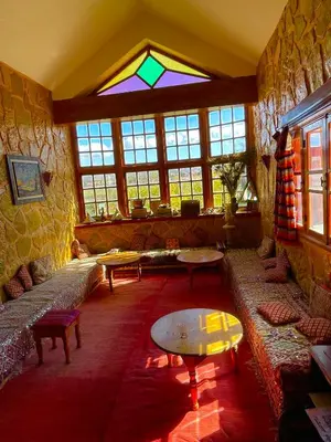 a large room with couches and a stained glass window at Ferme D’hôte La Vallée in Azrou