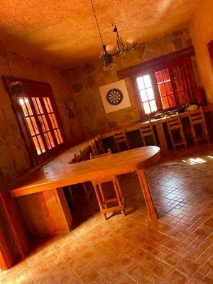 a dining room with a wooden table in a room at Ferme D’hôte La Vallée in Azrou