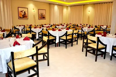 a dining room with white tables and chairs at Erfoud Palace in Erfoud