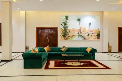 a living room with a green couch in a lobby at Erfoud Palace in Erfoud