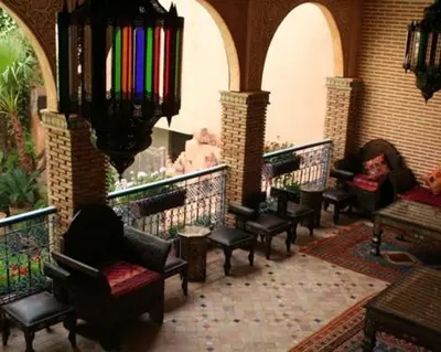 a lobby with chairs and tables and a chandelier at Le Riad Meknes in Meknès